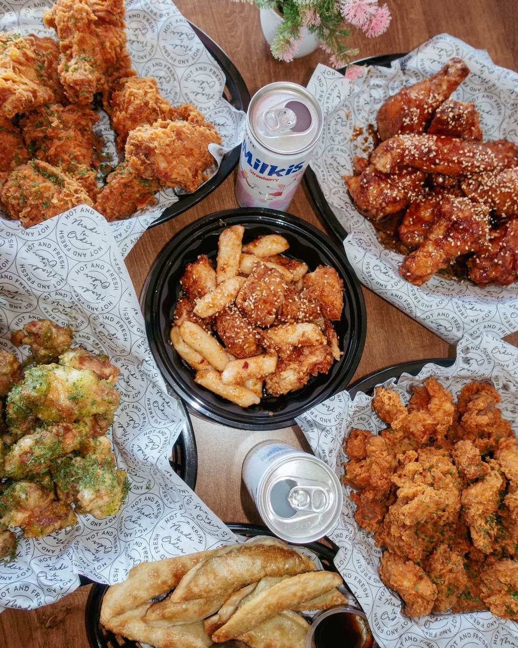 Kokio table spread: baskets of fried chicken, sauced wings, honey rice cake with chicken, and fried dumplings