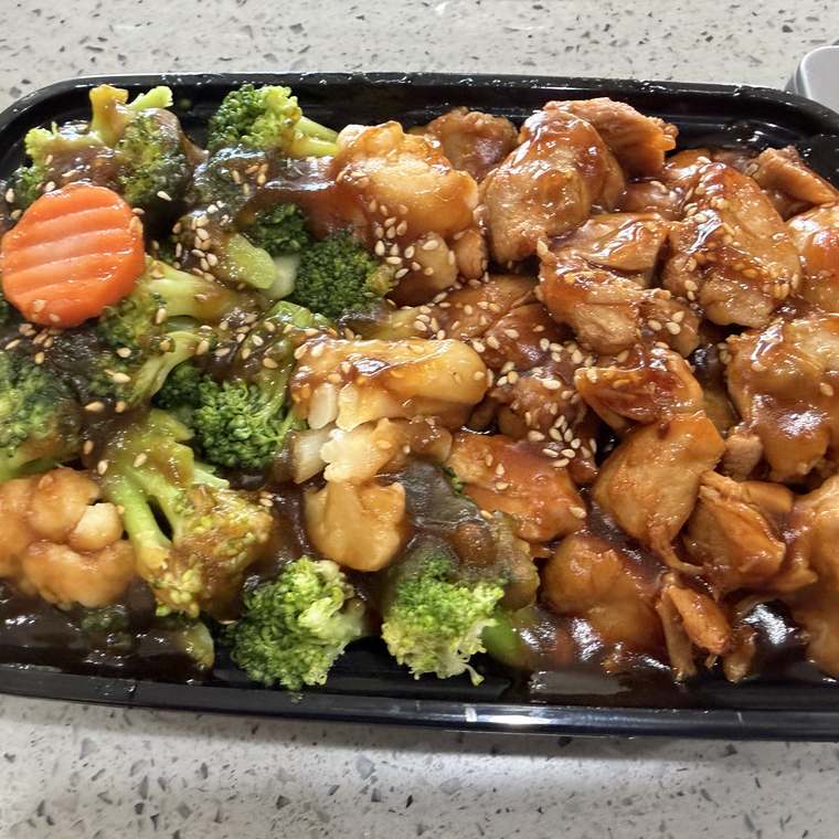 Teriyaki chicken over steamed rice with broccoli and carrots, sesame finished
